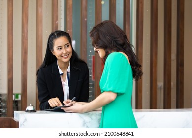 Friendly Receptionist Woman Working At Desk In Hotel Lobby. Leisure And Travel At Holidays.