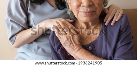 Friendly relationship between caregiver and happy eldery woman during nursing at home. Senior services and geriatric care concept. Stockfoto © 