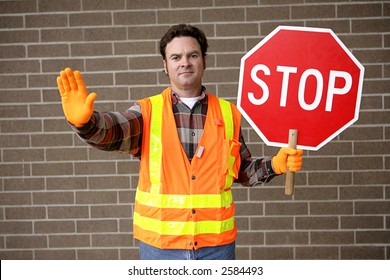 A Friendly School Crossing Guard Holding A Stop Sign.