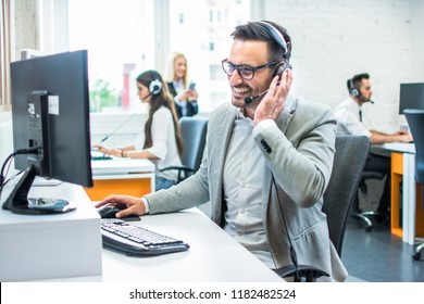 Friendly service agent talking to customer in call centre - Shutterstock ID 1182482524