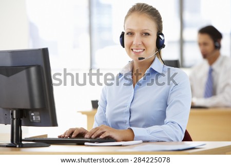 Friendly Service Agent Talking To Customer In Call Centre
