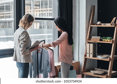 Friendly service. Beautiful young woman helping to choose clothes to her customer while working in the fashion boutique                 - Powered by Shutterstock