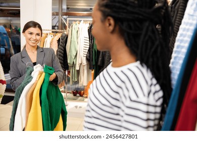 Friendly Shopping Assistant Helping Customer In Boutique Store, Smiling Women Choosing Fashionable Clothing, Enjoyable Retail Experience, Fashion And Style - Powered by Shutterstock