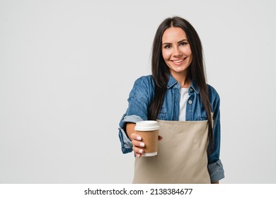 Friendly smiling caucasian young female woman barista bar tender coffee maker in apron giving holding coffee tea hot beverage cup with decaf sugar-free isolated in white - Powered by Shutterstock