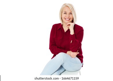 Friendly Smiling Middle-aged Woman Sitting On Chair Isolated On White Background