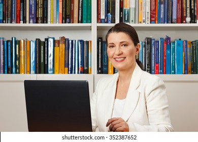 Friendly Smiling Woman In Front Of A Computer In A Library, Consultant, Counselor, Adviser, Customer Service, Online Helpline