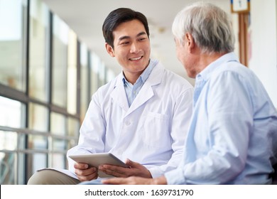 friendly smiling young asian doctor talking and explaining test result to elderly patient in hospital - Shutterstock ID 1639731790