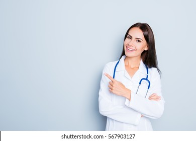 Friendly smiling young female doctor pointing with finger. - Powered by Shutterstock