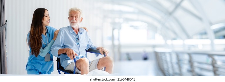 Friendly Staff Caregiver Of Nursing Home Talking To Elderly Man On Wheelchair In The Bedroom, Image Panorama For Cover Design.	