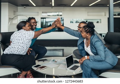 Friendly successful all african business team give high five together in office, excited happy employees celebrating corporate victory, african workers teambuilding concept