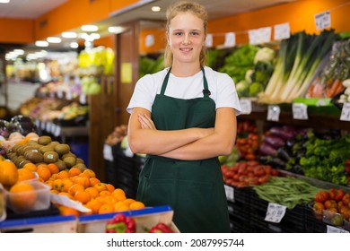 Friendly Teenage Girl Vegetable Shop Seller Posing In A Work Apron During Her First Day On A Job