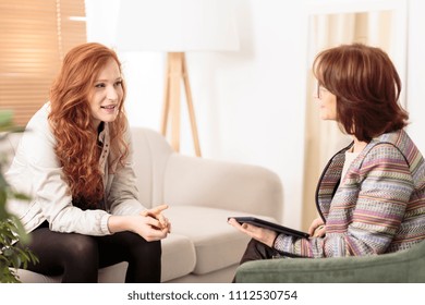 Friendly therapist supporting red-haired woman on how to manage health and life goals