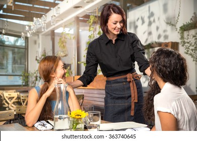 Friendly waiter server laughing smiling having fun with customer patron pretty modern