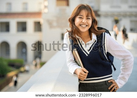 Friendly and warm Ivy League higher learning and intelligent student, lifestyle portrait with backpack and notebook on campus