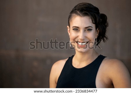 Friendly and warm portrait of a stylish young woman with a big natural smile, excited and happy person