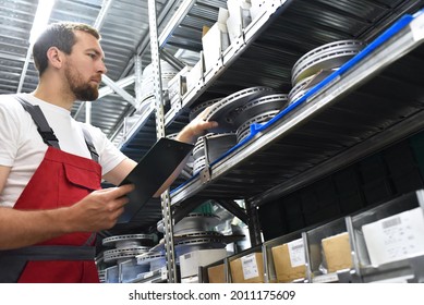 Friendly Worker In A Warehouse And Trade For Car Spare Parts Of A Car Repair Shop 