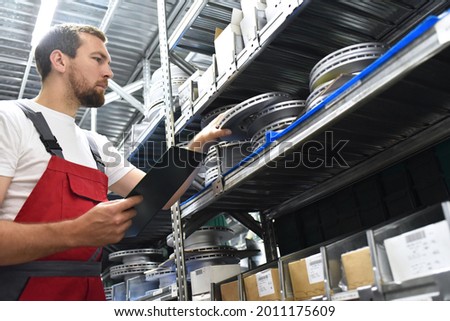 friendly worker in a warehouse and trade for car spare parts of a car repair shop 