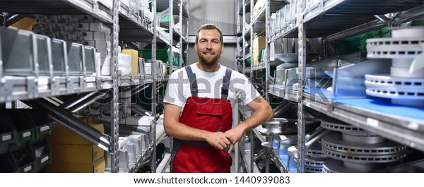 friendly worker in a warehouse and trade for car\
spare parts of a car repair shop\
