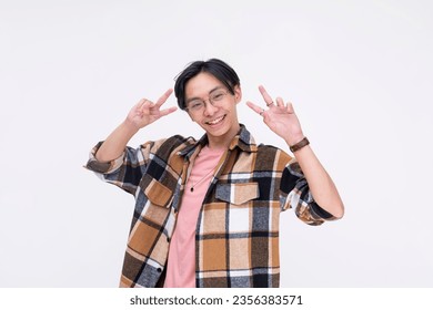 A friendly young asian man making two peace signs while smiling. Isolated on a white background.