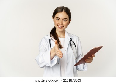 Friendly Young Female Doctor, Physician Stretch Out Hand For Handshake, Greeting Patient In Clinic, Holding Digital Tablet With Medical Data, White Background