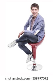 Friendly Young Guy Sitting On The Bar Stool On A White Background.