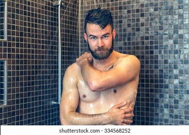 Friendly Young Man With A Full Beard Standing Soaping Himself In The Shower And Smiling At The Camera, Upper Body With Copy Space