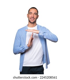 Friendly young man making a time out gesture with his hands