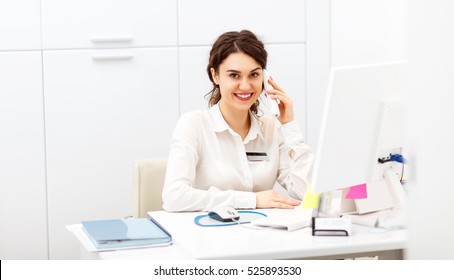 Friendly Young Woman Behind The Reception Desk Administrator