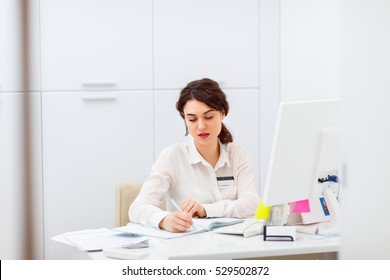 Friendly Young Woman Behind The Reception Desk Administrator