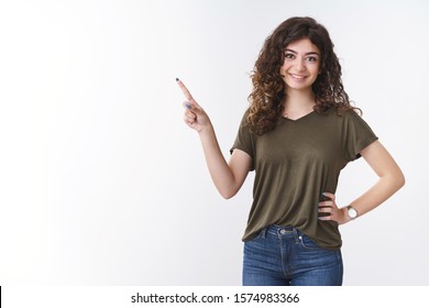 Friendly-looking charming determined cute armenian girl performing speech show coworkers chart pointing upper left corner standing confident relaxed pose, smiling broadly self-assured
