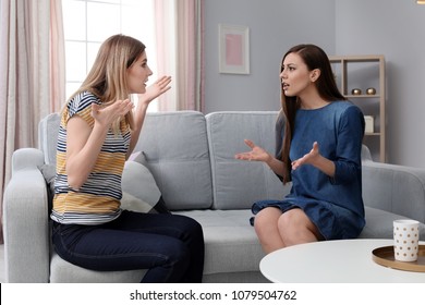 Friends Arguing On Sofa At Home