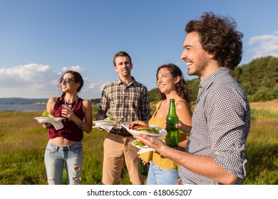 Friends at barbecue party in nature drinking beer and eating hamburger sandwiches - Shutterstock ID 618065207