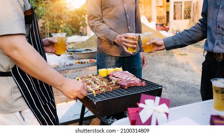 Friends And Bbq Party Hold A Plastic Beer Mug To Celebrate The New Year Holidays.