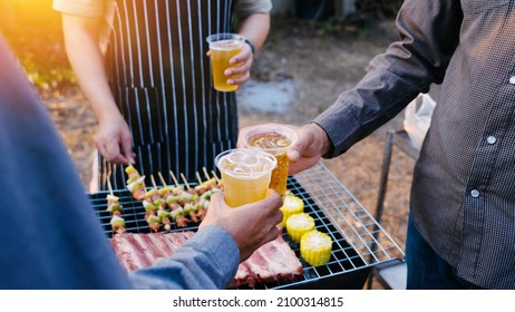 Friends And Bbq Party Hold A Plastic Beer Mug To Celebrate The New Year Holidays.