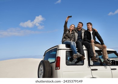 Friends, car and selfie in desert with smartphone with smile for adventure, holiday and road trip to travel. People, happy excited in sand dunes for vacation or break with bonding for memory - Powered by Shutterstock