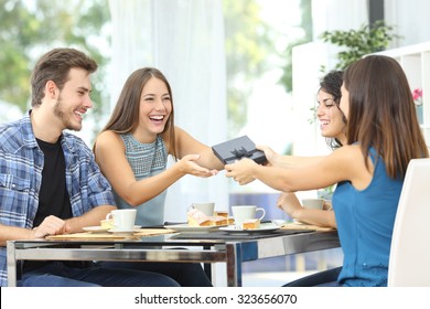 Friends Celebrating Birthday And Giving Gift To A Girl Sitting In A Dining Room