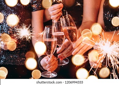 Friends celebrating Christmas or New Year eve party with Bengal lights and rose champagne. - Shutterstock ID 1206994333
