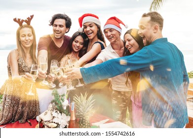 Friends Celebrating Christmas Or New Year Eve At The Beach. Party Table With Champagne.