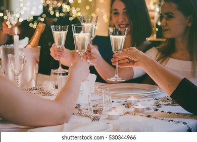 Friends Celebrating Christmas Or New Year Eve. Party Table With Champagne. Toned Picture