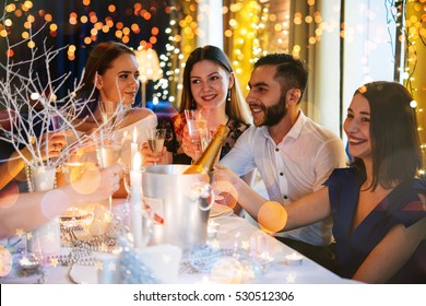 Friends Celebrating Christmas Or New Year Eve. Party Table With Champagne.