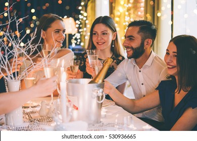 Friends Celebrating Christmas Or New Year Eve. Party Table With Champagne. Toned Picture