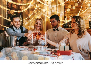 Friends Celebrating Christmas Or New Year Eve. Party Table With Rose Champagne.