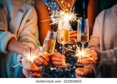 Friends celebrating Christmas or New Year's eve with Bengal lights and champagne. - Shutterstock ID 2223018655