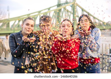 Friends Celebrating On A Terrace, Blowing Confetti