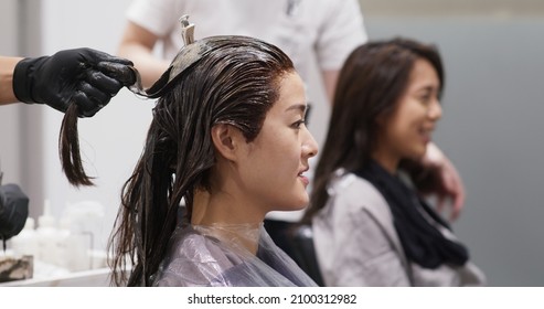 Friends chat and wait for the color dye on hair in salon