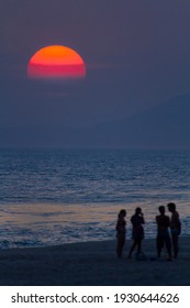 Friends Chatting At Sunset On The Beach
