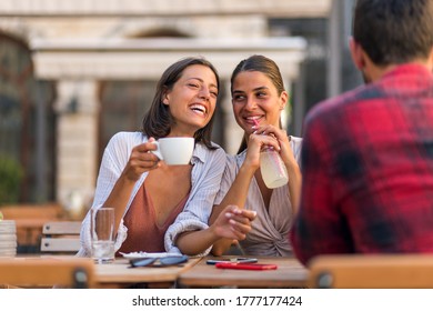 Friends chatting while drinking coffee at terrace