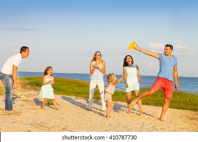 Friends with children playing with frisbee on the beach. Summer holiday and family concept - Powered by Shutterstock