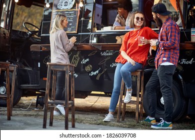 Friends Chilling Out With Beer In Front Of Food Truck