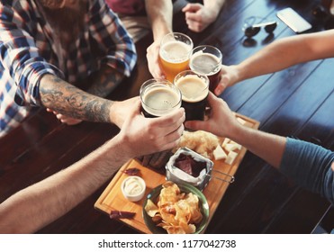 Friends Clinking Glasses With Beer In Pub